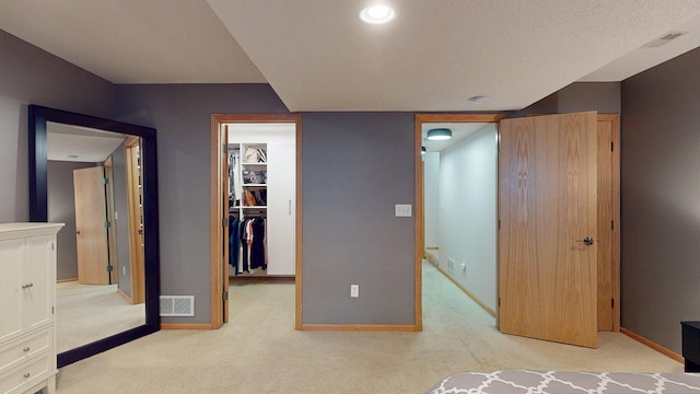 unfurnished bedroom featuring a spacious closet, carpet flooring, baseboards, a closet, and recessed lighting