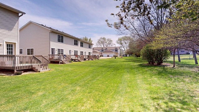 view of grassy yard with a deck
