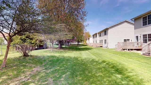 view of green lawn with a wooden deck