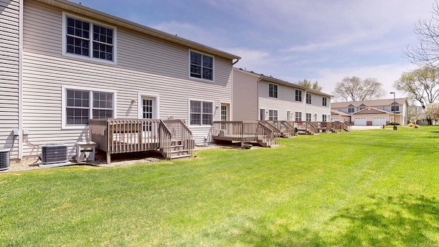 rear view of property with central air condition unit, a wooden deck, and a yard