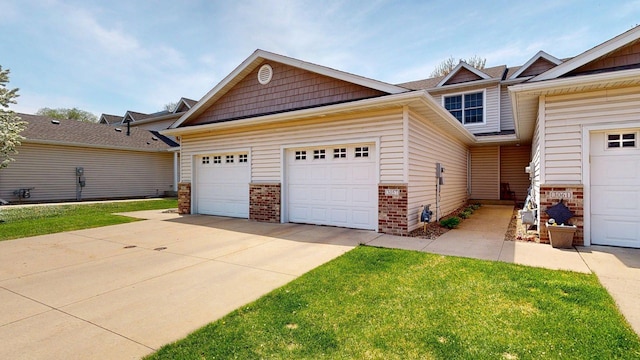 craftsman house with brick siding, driveway, a garage, and a front lawn