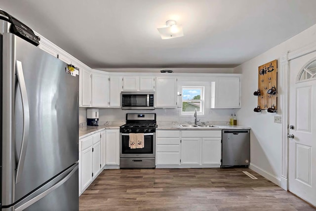 706 Broad St, Mankato, MN 56001 - kitchen featuring appliances with stainless steel finishes, a sink, white cabinetry, and dark wood-style flooring