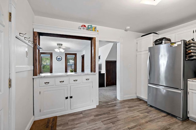 706 Broad St, Mankato, MN 56001 - kitchen with freestanding refrigerator, light countertops, white cabinets, and wood finished floors