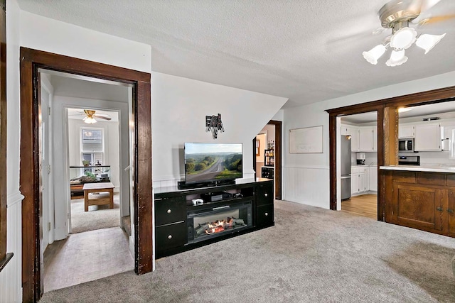 706 Broad St, Mankato, MN 56001 - living room featuring ceiling fan, light colored carpet, and a textured ceiling