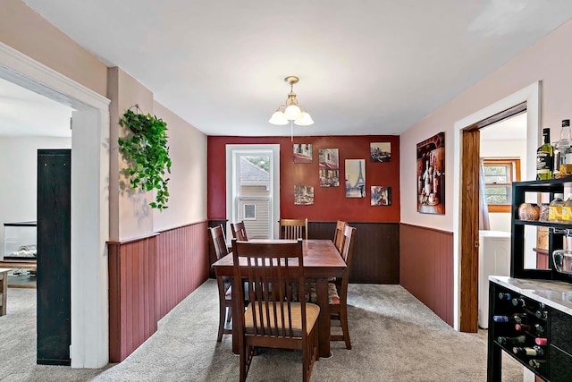 706 Broad St, Mankato, MN 56001 - carpeted dining room with a wainscoted wall, a chandelier, and wooden walls
