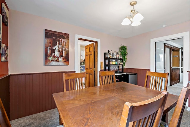 706 Broad St, Mankato, MN 56001 - dining room with carpet, a chandelier, a wainscoted wall, and wooden walls