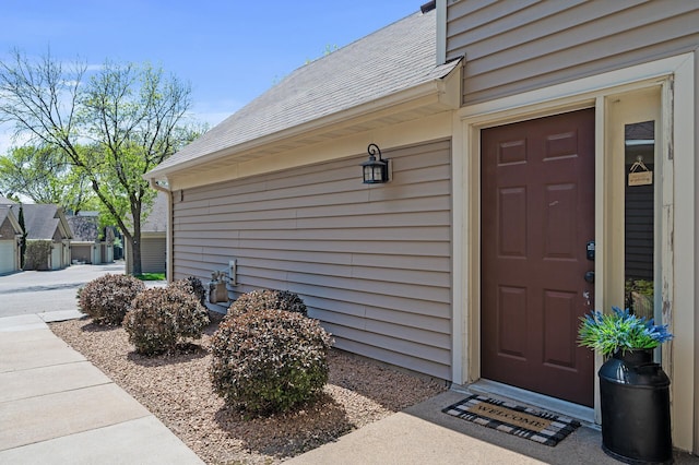 entrance to property with a shingled roof