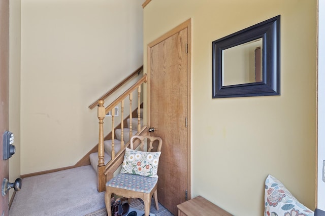 sitting room featuring carpet floors, stairs, and baseboards