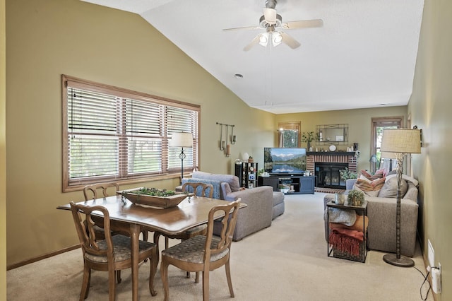 dining space with carpet, a ceiling fan, lofted ceiling, a fireplace, and baseboards