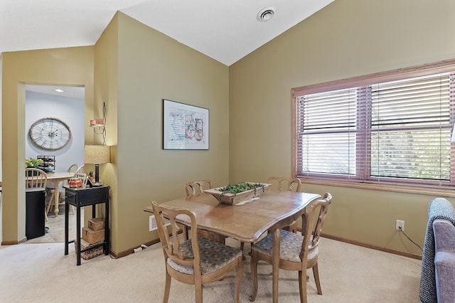 dining area with lofted ceiling, light carpet, and baseboards
