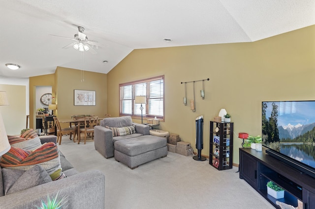 living area with vaulted ceiling, a ceiling fan, and light carpet