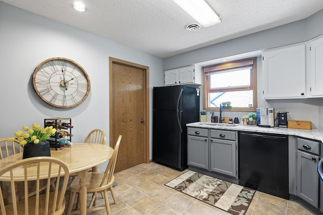 kitchen with black appliances, gray cabinetry, a sink, white cabinets, and a textured ceiling