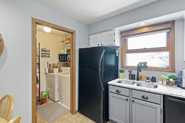 kitchen featuring separate washer and dryer, a sink, black appliances, gray cabinetry, and light tile patterned floors