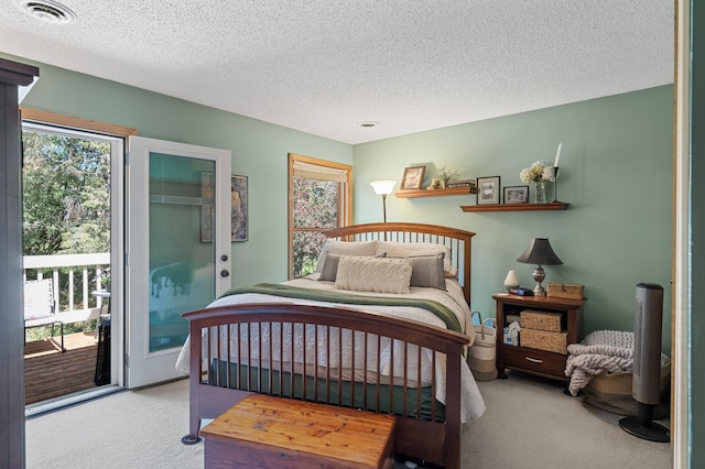 bedroom with carpet floors, access to outside, and a textured ceiling