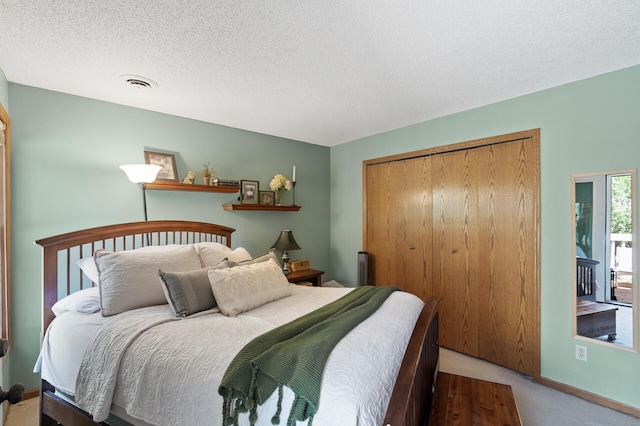 bedroom with carpet floors, a closet, a textured ceiling, and baseboards