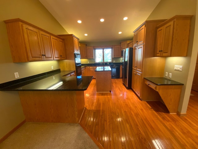 kitchen with black appliances, recessed lighting, a peninsula, brown cabinets, and dark countertops