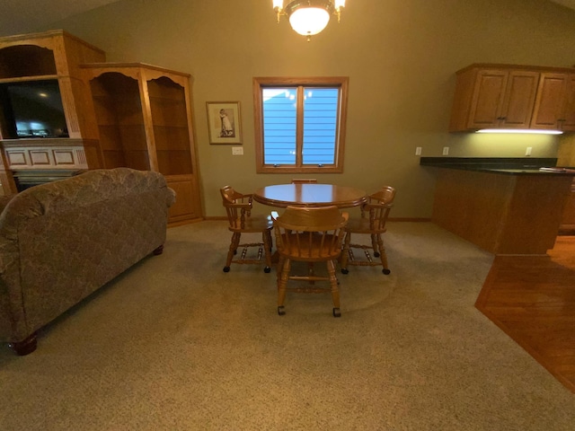 dining space featuring light carpet, baseboards, and high vaulted ceiling