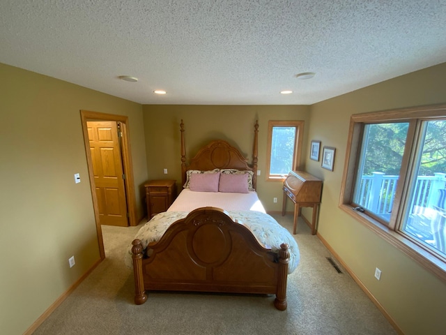 bedroom with multiple windows, a textured ceiling, light carpet, recessed lighting, and baseboards