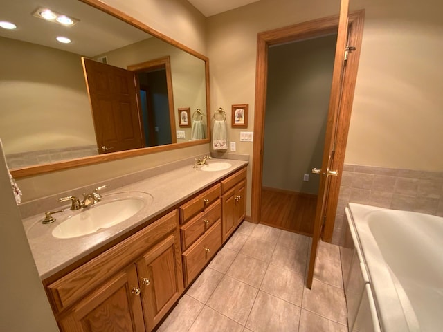 bathroom featuring tile patterned floors, a tub, and double vanity