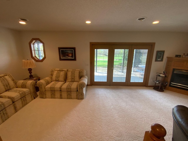 carpeted living room with recessed lighting, a glass covered fireplace, and baseboards