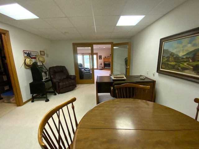 dining area featuring a paneled ceiling and carpet