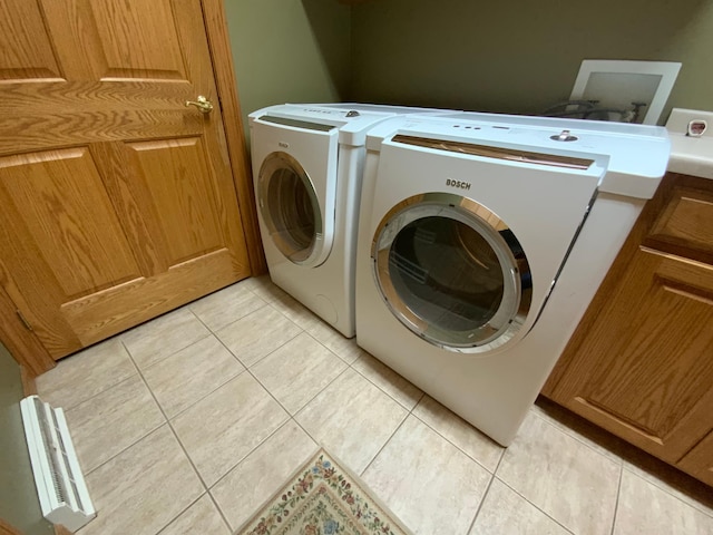 laundry room with separate washer and dryer, light tile patterned floors, and cabinet space