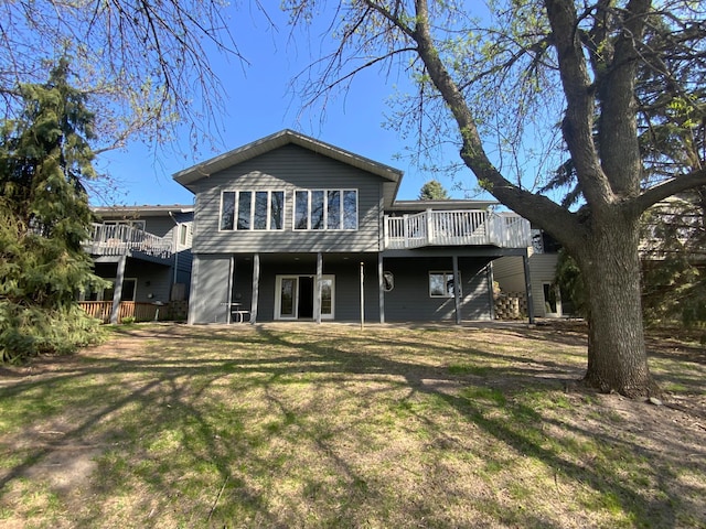 rear view of house with a deck and a lawn