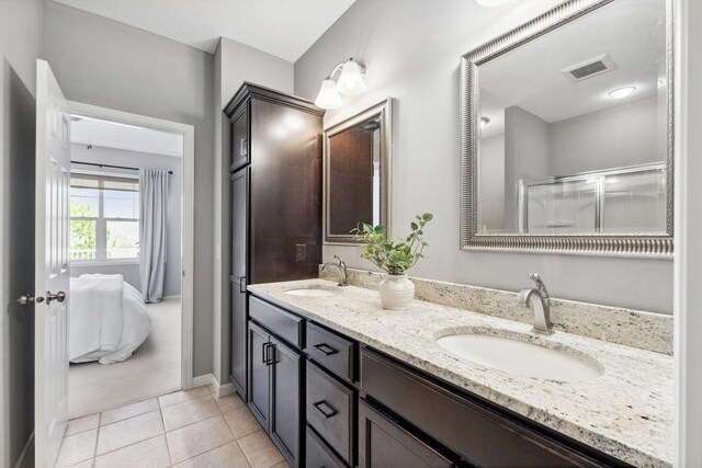 8172 Virginia Ln, Savage, MN 55378 - full bathroom with double vanity, connected bathroom, tile patterned floors, a shower with door, and baseboards