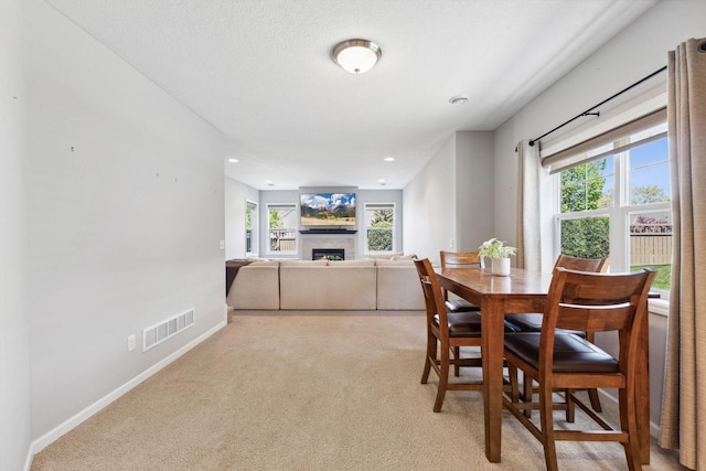 8172 Virginia Ln, Savage, MN 55378 - dining area with light carpet, a warm lit fireplace, baseboards, and recessed lighting