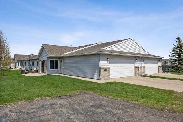 view of home's exterior with a lawn, an attached garage, a shingled roof, driveway, and an outdoor hangout area