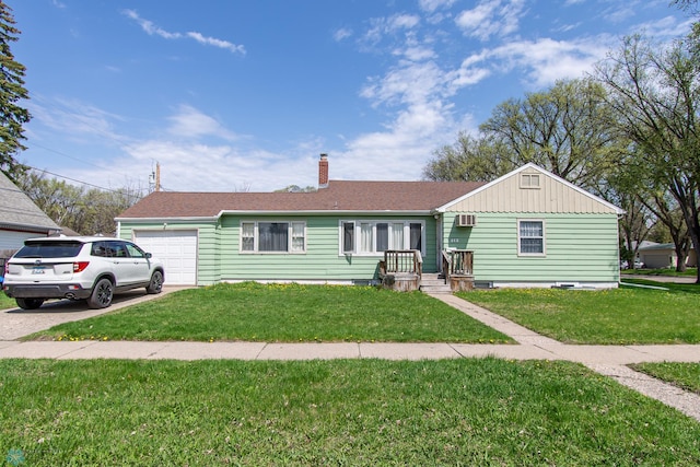 single story home with an attached garage, a front lawn, a chimney, and driveway