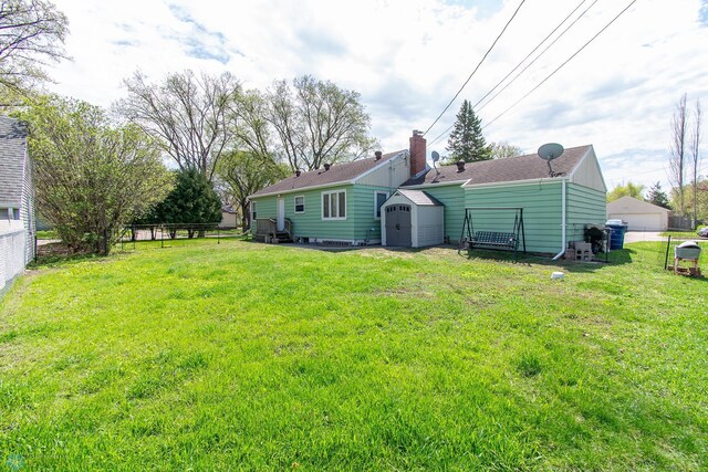 rear view of house featuring a storage shed and an outbuilding