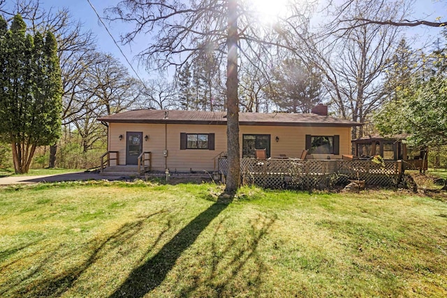 back of house with a lawn and a deck