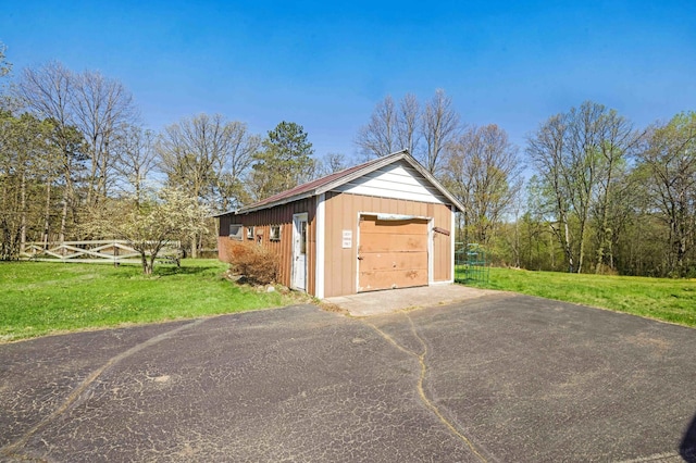 detached garage featuring asphalt driveway