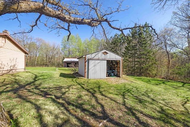 view of green lawn with an outbuilding and a garage