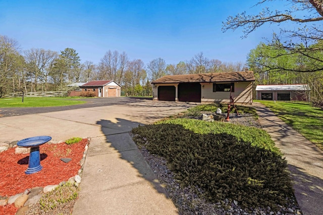 view of side of home with fence, an outbuilding, and a garage