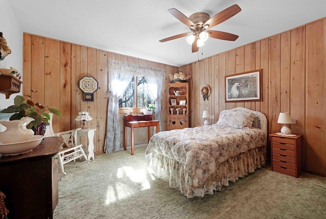 bedroom with carpet, wooden walls, and a ceiling fan