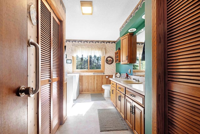 bathroom with a closet, wallpapered walls, toilet, plenty of natural light, and vanity