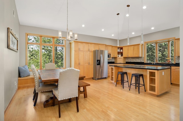 dining space with light wood-type flooring, plenty of natural light, a chandelier, and recessed lighting