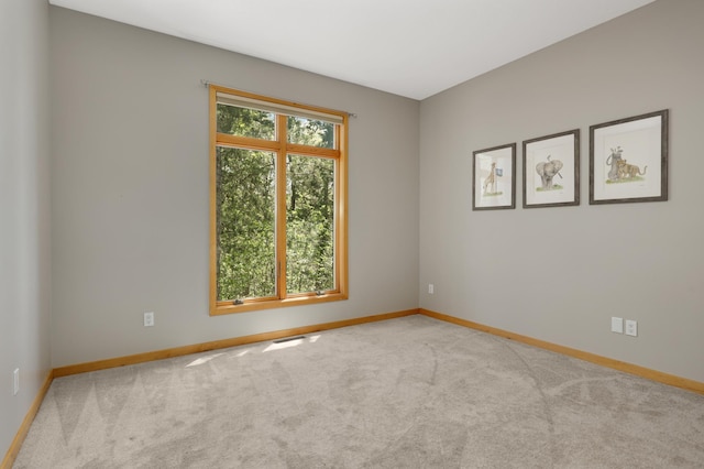 carpeted empty room with baseboards