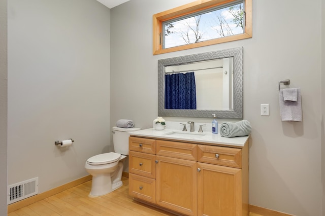 bathroom with wood finished floors, baseboards, toilet, vanity, and a shower with shower curtain