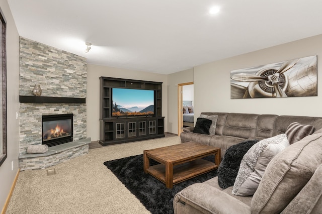 living room with carpet and a stone fireplace