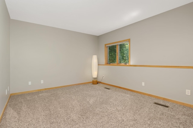 carpeted spare room featuring baseboards