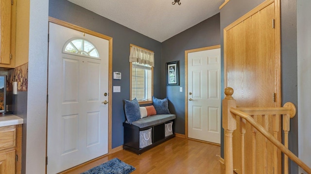2647 Olive Ln, Sauk Rapids, MN 56379 - entryway featuring vaulted ceiling, light wood-type flooring, a textured ceiling, and baseboards