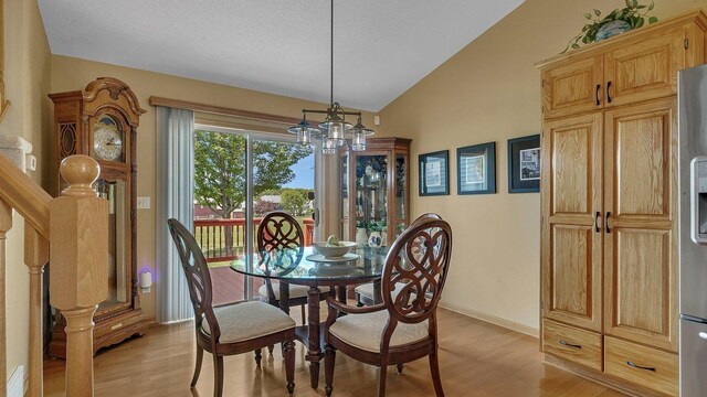 2647 Olive Ln, Sauk Rapids, MN 56379 - dining room featuring a chandelier, light wood finished floors, vaulted ceiling, and baseboards