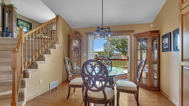 2647 Olive Ln, Sauk Rapids, MN 56379 - dining space featuring wood finished floors, a chandelier, and baseboards