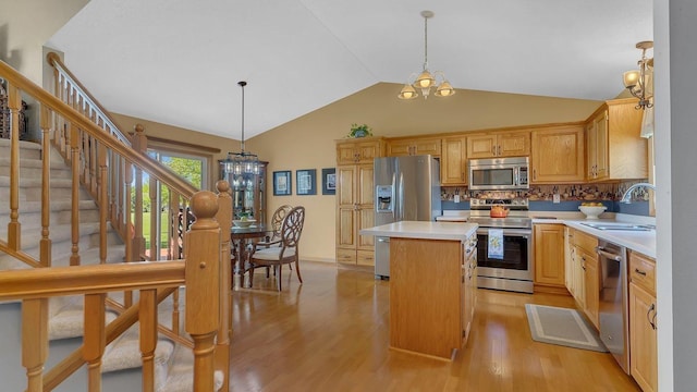 2647 Olive Ln, Sauk Rapids, MN 56379 - kitchen with appliances with stainless steel finishes, a chandelier, light countertops, a center island, and vaulted ceiling