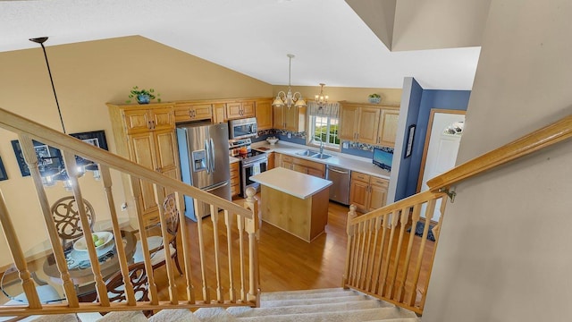 2647 Olive Ln, Sauk Rapids, MN 56379 - kitchen with stainless steel appliances, a sink, light wood finished floors, a chandelier, and a center island