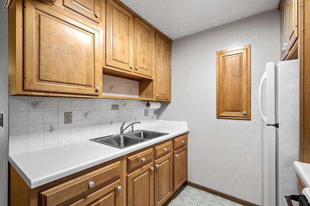 2700 Oxford St N Unit 102, Roseville, MN 55113 - kitchen with a sink, freestanding refrigerator, tasteful backsplash, light countertops, and baseboards