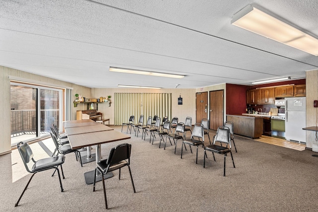 2700 Oxford St N Unit 102, Roseville, MN 55113 - dining space with a textured ceiling, light colored carpet, and wooden walls